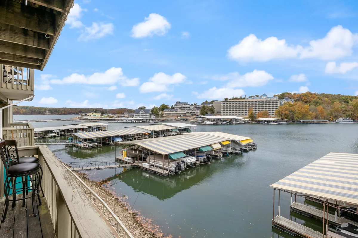 A scenic lake view with boathouses and surrounding green hills, evoking a peaceful, natural setting. The image highlights the proximity to water activities and the serene beauty of the region, suggesting boating, fishing, or simply relaxing by the lake as a family.