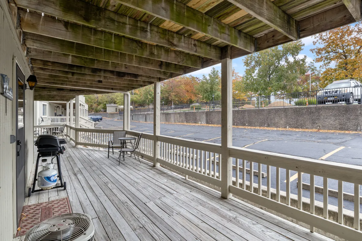 A wooden deck with comfortable chairs and a barbecue grill, set up for outdoor relaxation, grilling, or family meals. The scene is casual and welcoming, ideal for unwinding after a day of exploration or sharing a meal together while enjoying views and fresh air.
